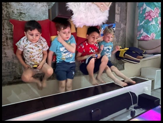 Ali, Omar, Mohammed, and Zaid watching tv on the floor during the second day of war, Oct 8th. They had gathered in Amal's brother Ali’s home in Remal because they thought his home was the safest.<span class="copyright">Courtesy Murtaja</span>