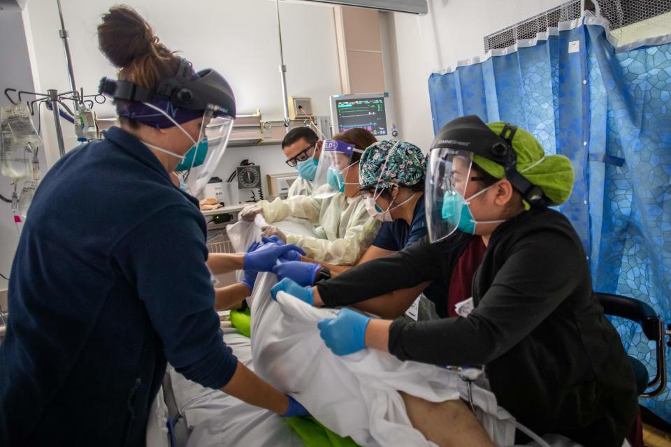 Health care workers attend to a patient with Covid-19 as they prepare to turn the 46 year old unvaccinated patient from his stomach onto his back at Providence Cedars-Sinai Tarzana Medical Center in Tarzana, California on September 2, 2021. (Photo by Apu GOMES / AFP)