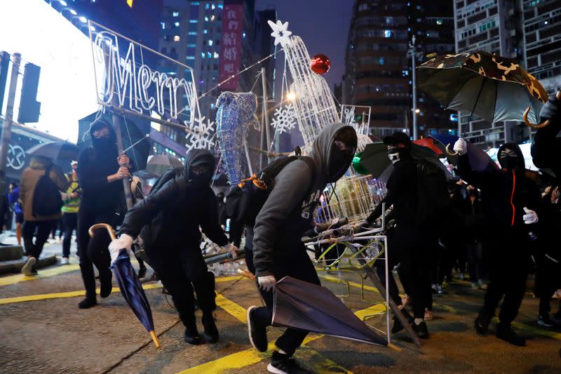 Anti-government protesters tear down Christmas and New Year's decorations during a demonstration on New Year's Eve outside Mong Kok police station in Hong Kong