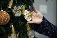 Suzanne Jaber of The Eid Shop holds an ornament she created and sells in Dearborn Heights, Mich., on Monday, March 27, 2023. More businesses are selling Ramadan and Eid items, including DIY kits, lanterns and napkin holders. She began crafting and selling her own dedicated Ramadan and Eid decorations and now ships items across the U.S. and world. (AP Photo/Carlos Osorio)