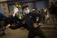 A man throws a bouquet of flowers against a national police station during a protest condemning the arrest of rap singer Pablo Hasel in Barcelona, Spain, Monday, Feb. 22, 2021. The imprisonment of Pablo Hasel for inciting terrorism and refusing to pay a fine after having insulted the country's monarch has triggered a social debate and street protests. (AP Photo/Emilio Morenatti)