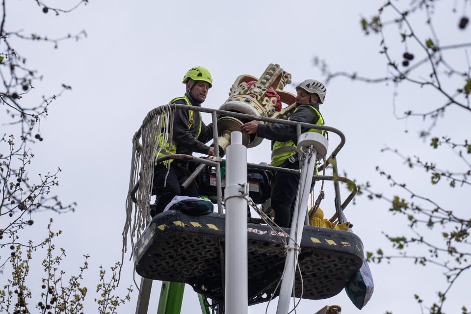 A crown is lifted into place atop a flag pole on The Mall on April 17.<span class="copyright">Carl Court—Getty Images</span>