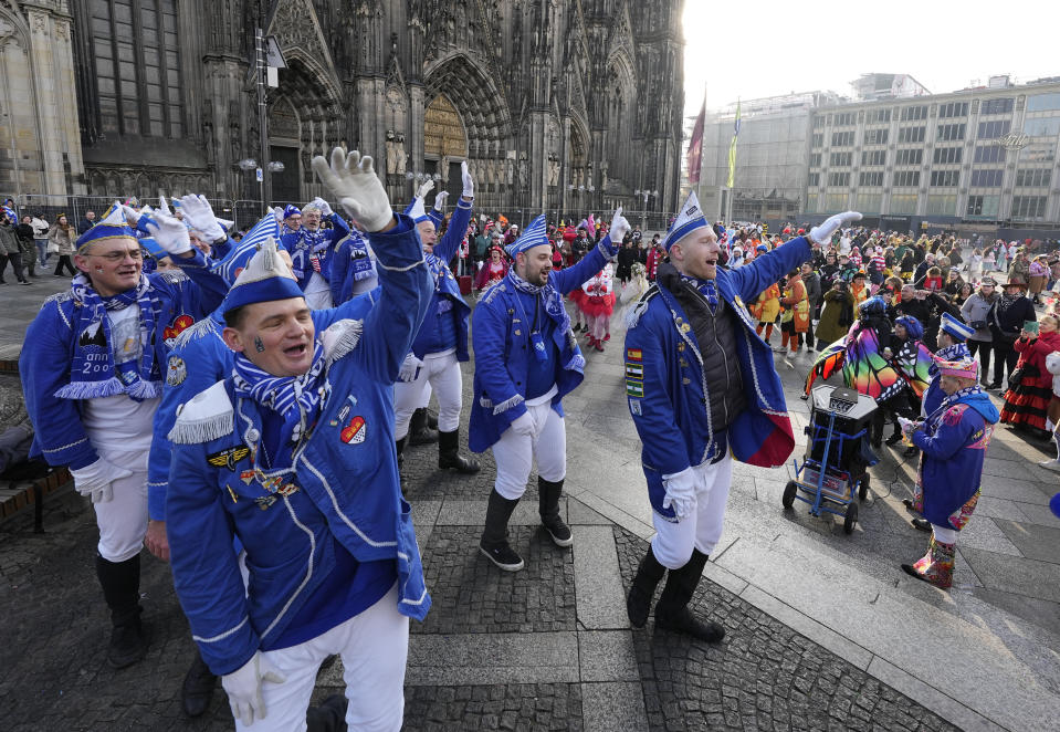 Revellers dance in front of the Cologne Cathedral at the start of the street carnival in Cologne, Germany, Thursday, Feb. 16, 2023. Hundreds of thousands will celebrate the carnival without any coronavirus restrictions in the streets of the German carnival capital. (AP Photo/Martin Meissner)