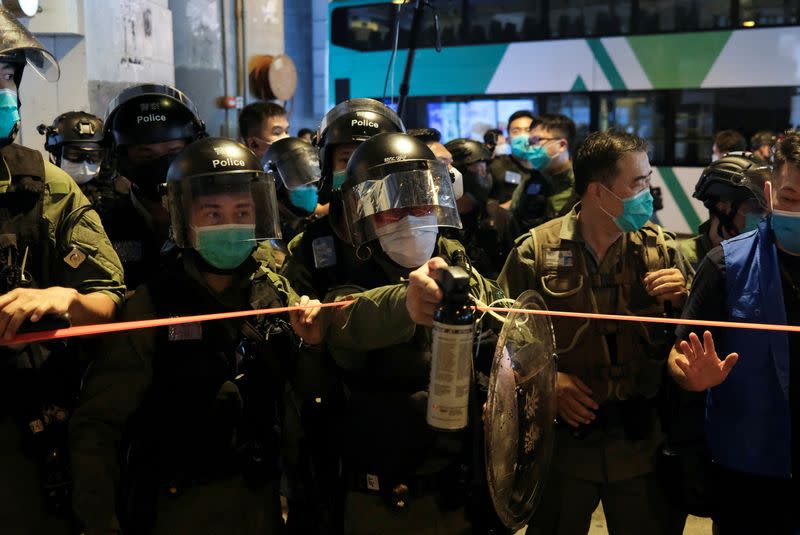 FILE PHOTO: A police officer holds a pepper spray to disperse pro-democracy protesters gathering to mark the anniversary of the attack by more than 100 white-wearing men with pipes and poles on July 21 last year, at Yuen Long, in Hong Kong