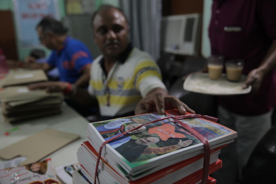 This Aug. 19, 2019, photo shows members of Kashmiri Samiti, an organization of Kashmiri Hindus in New Delhi, packing their monthly magazine which features celebration of abrogation of Article 370 that gave special privileges to Indian-administered Kashmir. Though people in Muslim-majority Kashmir have been protesting the Indian government’s move, Kashmiri Hindus, who had to flee from their homes nearly three decades ago, view it as a step towards justice. (AP Photo/Rishabh R. Jain.)