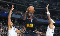 Denver Nuggets guard Reggie Jackson, center, drives to the basket between Minnesota Timberwolves forward Kyle Anderson, left, and guard Nickeil Alexander-Walker, right, in the first half of Game 2 of an NBA basketball second-round playoff series Monday, May 6, 2024, in Denver. (AP Photo/David Zalubowski)