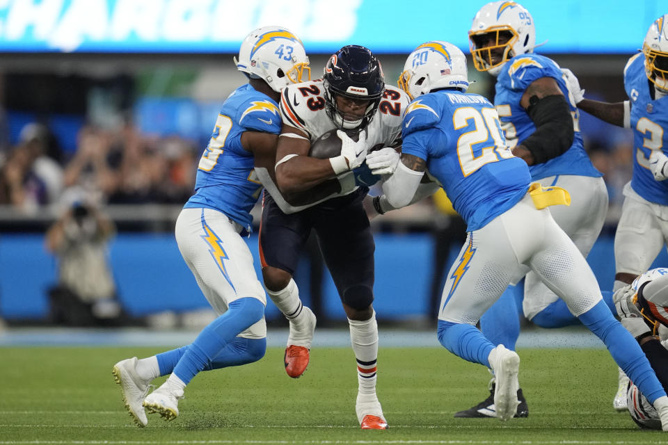 Chicago Bears running back Roschon Johnson, center, carries the ball as he pushes past Los Angeles Chargers safety Dean Marlowe, right, and cornerback Michael Davis during the first half of an NFL football game Sunday, Oct. 29, 2023, in Inglewood, Calif. (AP Photo/Ashley Landis)