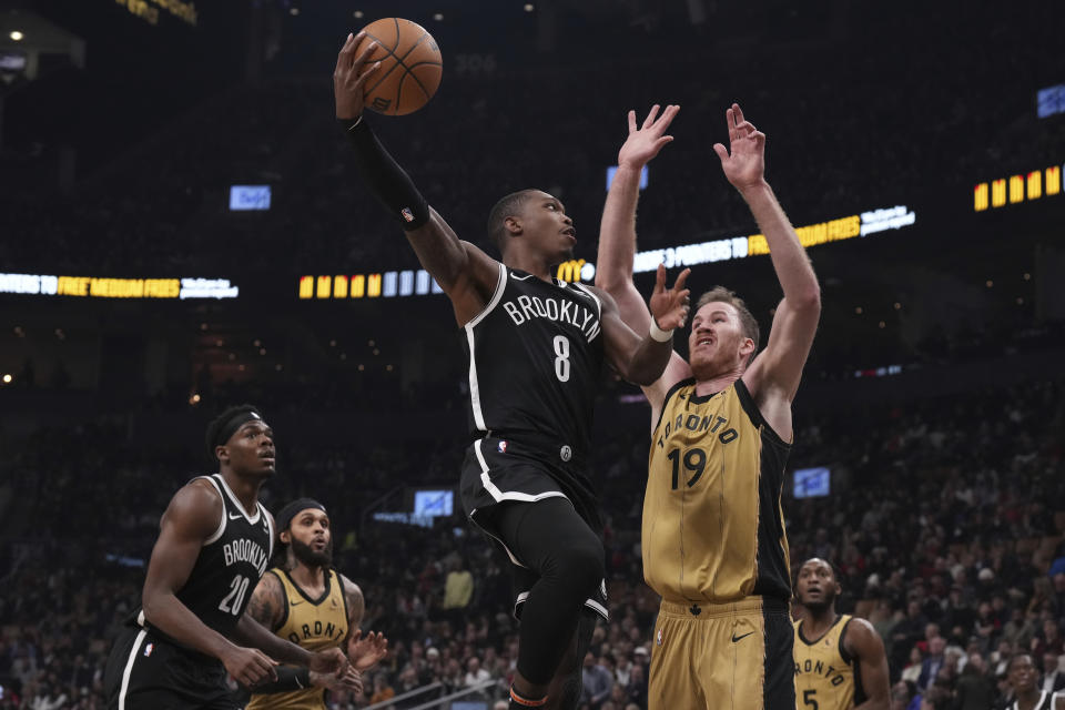 Brooklyn Nets' Lonnie Walker IV (8) shoots over Toronto Raptors' Jakob Poeltl (19) during first-half NBA basketball game action in Toronto, Thursday, Feb. 22, 2024. (Chris Young/The Canadian Press via AP)