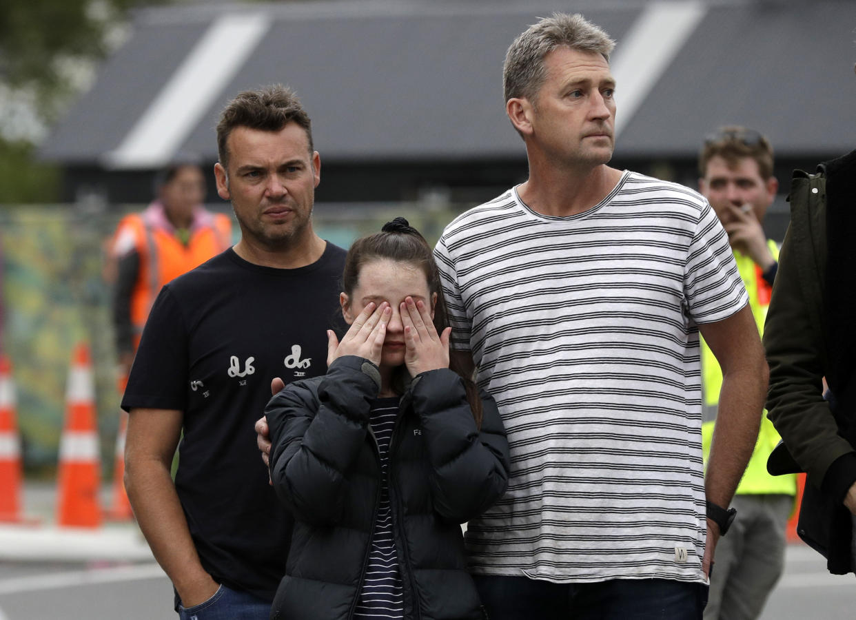 Mourners pay their respects at a makeshift memorial near the Masjid Al Noor mosque in Christchurch, New Zealand, Saturday, March 16, 2019. People across New Zealand are reaching out to Muslims in their communities and around the country the day after mass shootings at two mosques that left dozens of people dead. (AP Photo/Mark Baker)