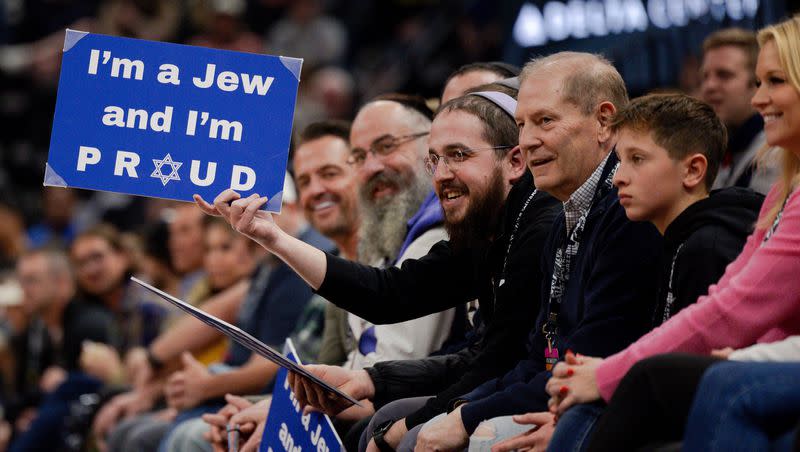 Rabbi Avremi Zippel holds up a sign that says “I’m a Jew and I’m Proud” during the NBA basketball game between the Utah Jazz and the Dallas Mavericks at the Delta Center in Salt Lake City on Monday, Jan. 1, 2024.