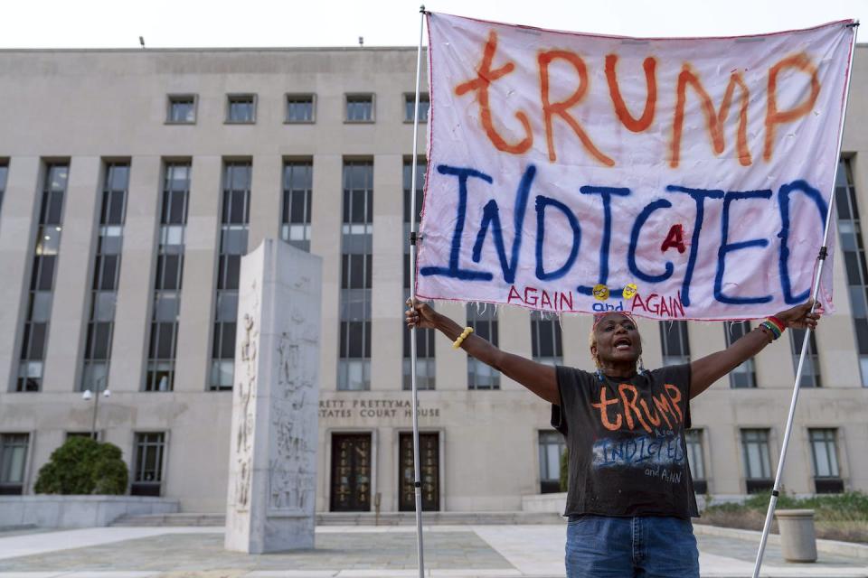 Un manifestant anti-Trump tient une banderole devant le tribunal fédéral de Washington après que l’ex-président a été inculpé par le ministère américain de la Justice pour ses efforts visant à renverser les résultats de l’élection présidentielle de 2020. (AP Photo/Jose Luis Magana)