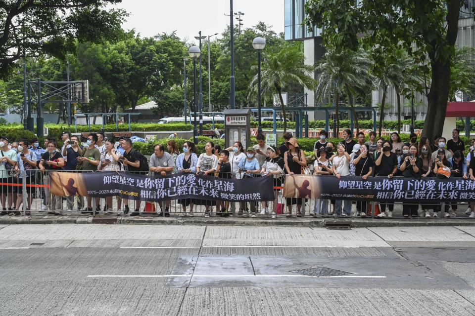 People wait outside a funeral home to pay their respects to Coco Lee in Hong Kong, Tuesday, Aug. 1, 2023. Lee was being mourned by family and friends at a private ceremony Tuesday a day after fans paid their respects at a public memorial for the Hong Kong-born entertainer who had international success. (AP Photo/Billy H.C. Kwok)