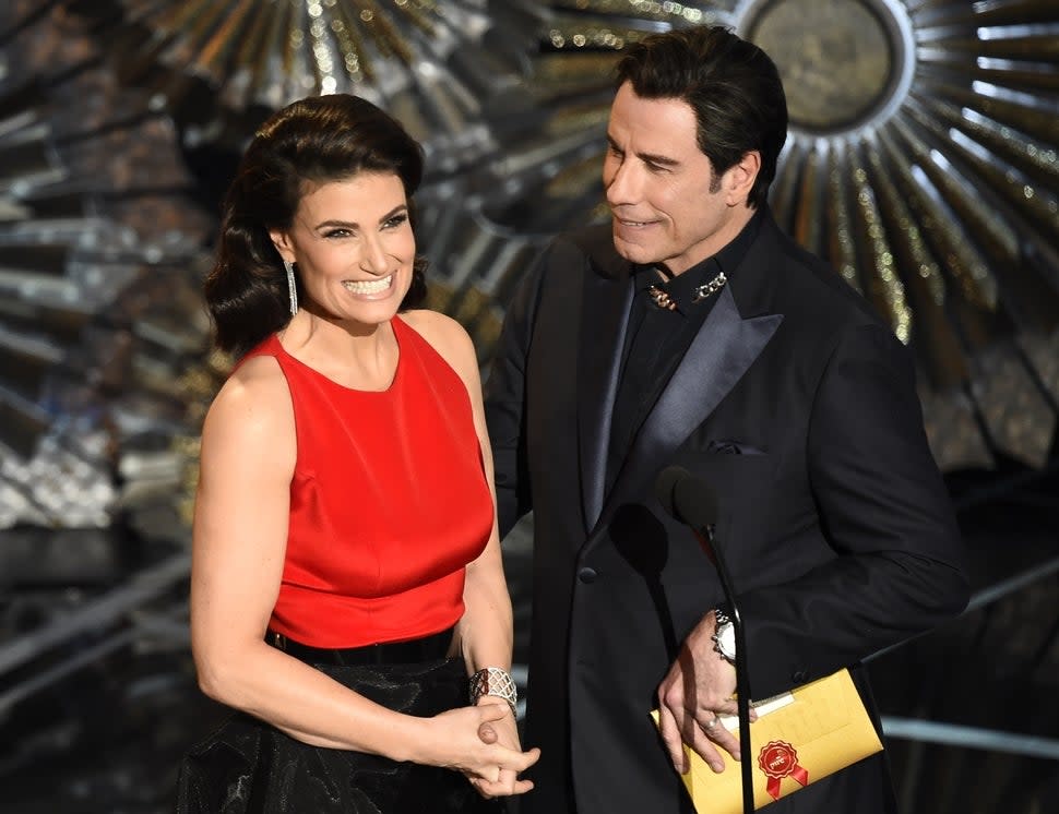 John Travolta and Idina Menzel present an award on stage at the 87th Oscars February 22, 2015 in Hollywood, California.