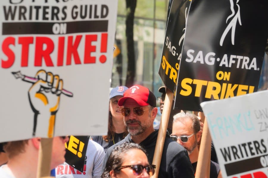 Actor Jason Sudeikis, center, walks a picket line with striking writers and actors, Friday, July 14, 2023, at NBC Universal Studios in New York. The picketing comes a day after the main actors’ union voted to join screenwriters in a double-barreled strike for the first time in more than six decades. The dispute immediately shut down production across the entertainment industry after talks for a new contract with studios and streaming services broke down. (AP Photo/Bebeto Matthews)