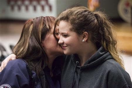 Rachel Sarzynski (L) kisses her daughter, Patience, after hearing the results of a union vote at the International Association of Machinists District 751 Headquarters in Seattle, Washington November 13, 2013. REUTERS/David Ryder