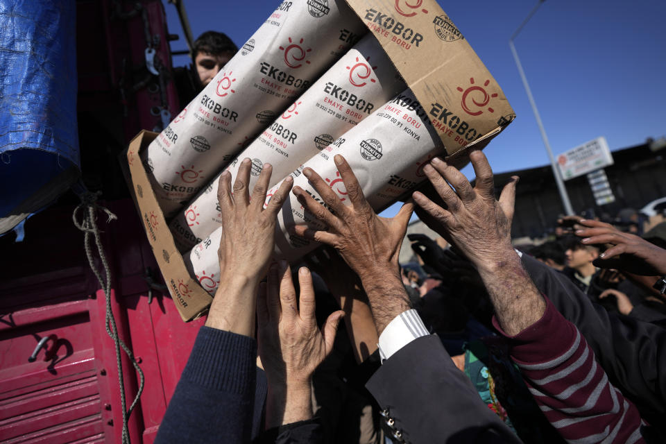 FILE - Volunteers distribute aid to people in Antakya, southern Turkey, Wednesday, Feb. 8, 2023. The 2011 quake, tsunami and nuclear meltdown in northern Japan provides a glimpse of what Turkey and Syria could face in the years ahead. No two events are alike, but the recent disaster resembles Japan's in the sheer enormity of the psychological trauma, of the loss of life and of the material destruction. (AP Photo/Khalil Hamra, File)