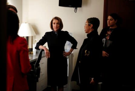 FILE PHOTO: House Minority Leader Nancy Pelosi (D-CA) speaks with members of her staff before speaking to the media on Capitol Hill in Washington, U.S., December 13, 2018.  REUTERS/Joshua Roberts/File Photo