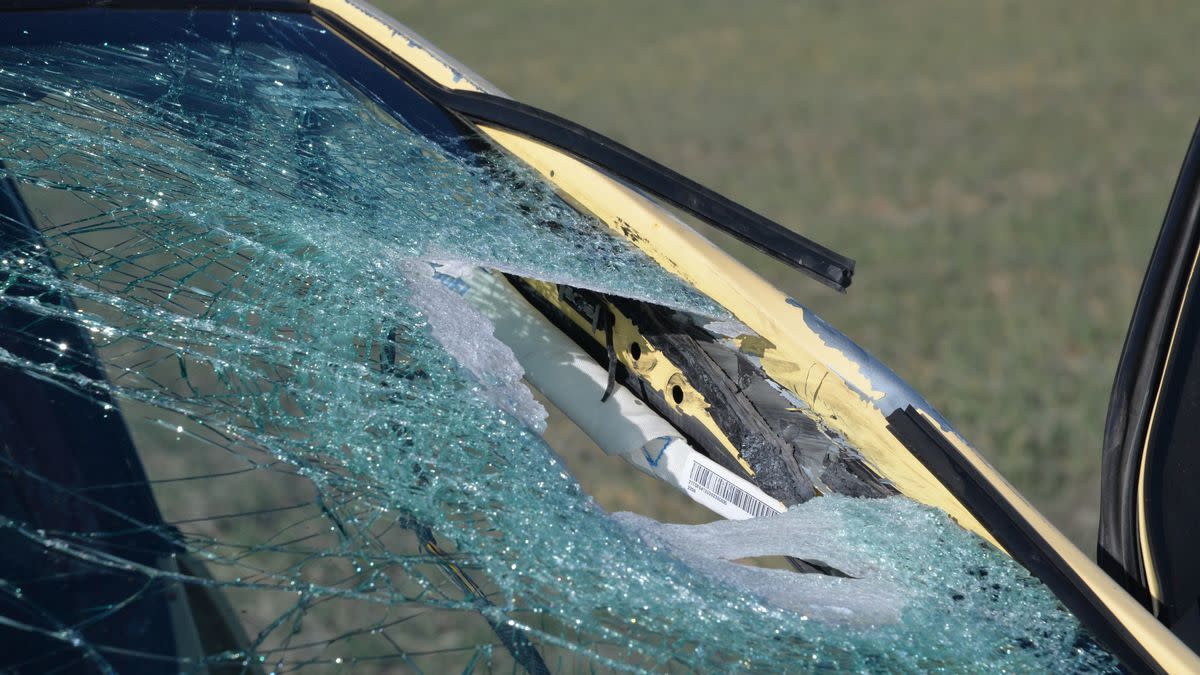 A shattered windshield with a foot-square hole.