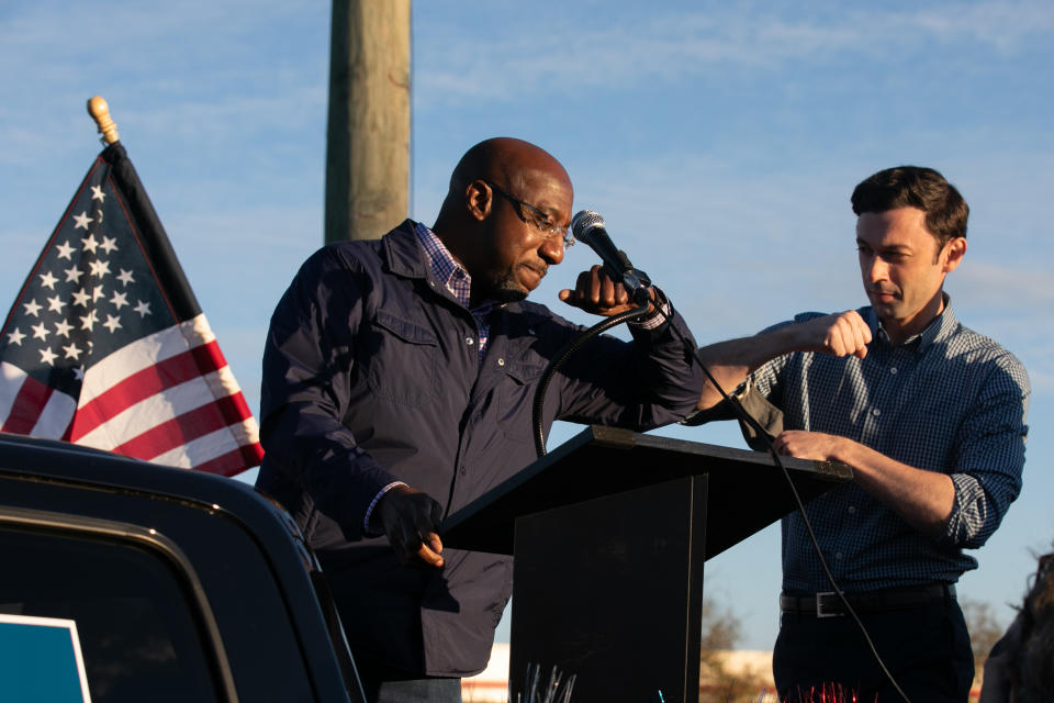 Georgia Democratic U.S. Senate candidates Jon Ossoff (R) and Raphael Warnock (L) taps elbows during a rally for supporters on November 15, 2020 in Marietta, Georgia. (Jessica McGowan/Getty Images)                                  