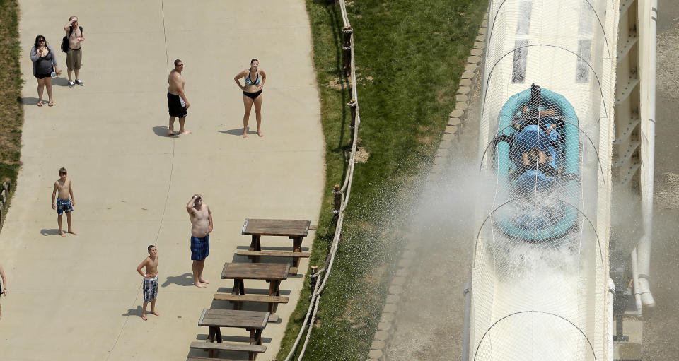 Riders are propelled by jets of water as they go over a hump while riding a water slide called