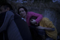 Iryna Sokeryna holds her daughter Liubov Sokeryna as they take cover from Russian shelling while being evacuated from a flooded neighborhood in Kherson, Ukraine, Tuesday, June 6, 2023. (AP Photo/Felipe Dana)