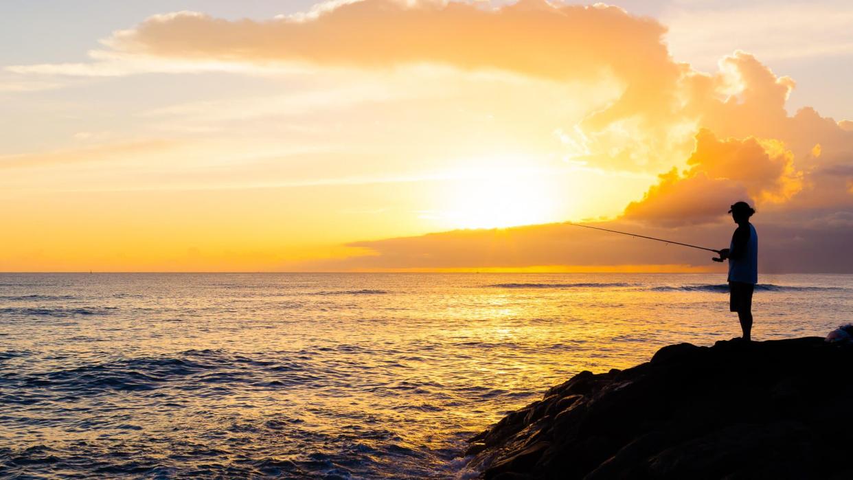 Man fishing during sunset.