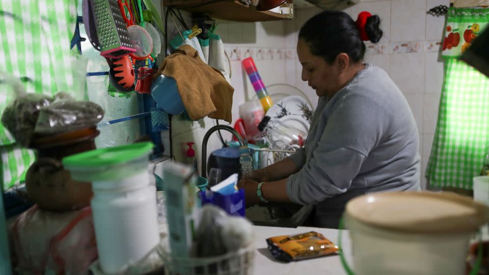 A woman washes the dishes in her home after receiving a free distribution of water in the Iztapalapa neighborhood on January 31, 2024. - Henry Romero/Reuters