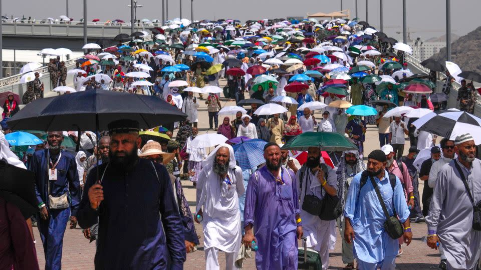 Muslim pilgrims use umbrellas to shield themselves from the sun. - Rafiq Maqbool/AP