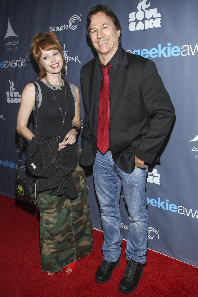 FILE - In this Aug. 18, 2013 file photo, actor Richard Hatch, right, and guest arrive at the 2013 Geekie Awards at the Avalon in Los Angeles. Hatch, perhaps best known for playing Captain Apollo in the original "Battlestar Galactica" film and TV series, has died at age 71. A representative for the actor says Hatch died Tuesday afternoon, Feb. 7, 2017, after a battle with pancreatic cancer. (Photo by Paul A. Hebert/Invision/AP, File)