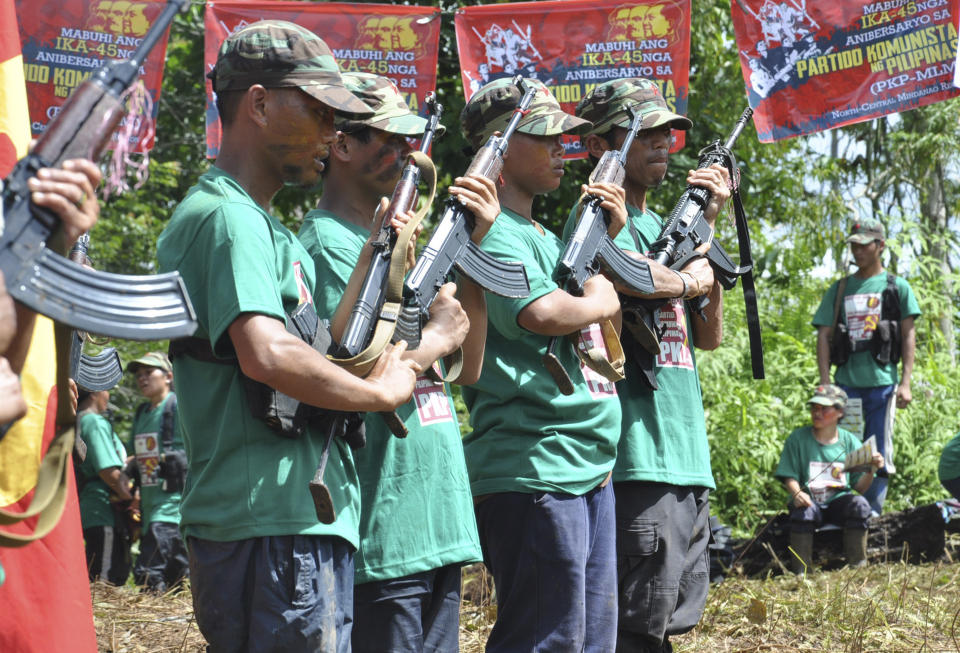 FILE - Communist New People's Army (NPA) rebels hold weapons in formation in the hinterlands of Davao, southern Philippines, on Thursday, Dec. 26, 2013. The Philippine government and the country’s communist rebels have agreed to resume talks aimed at ending decades of armed conflict, one of Asia's longest, Norwegian mediators announced Tuesday, Nov. 28, 2023. (AP Photo, File)
