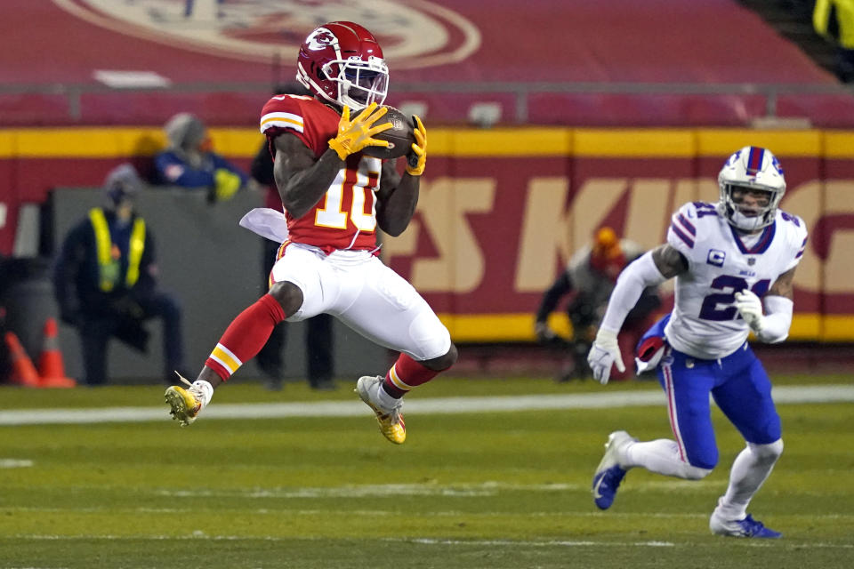 Kansas City Chiefs wide receiver Tyreek Hill (10) catches a pass ahead of Buffalo Bills safety Jordan Poyer, right, during the first half of the AFC championship NFL football game, Sunday, Jan. 24, 2021, in Kansas City, Mo. (AP Photo/Jeff Roberson)