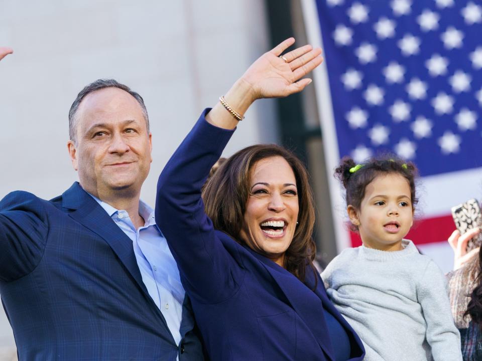 Kamala Harris and Doug Emhoff wave to supporters at her campaign launch rally