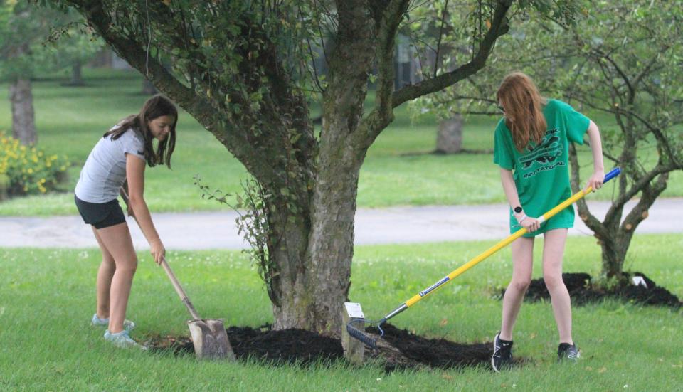 Abbi Dose, left, and freshman Sydney Thompson, spread mulch around a tree at Geller Park in preparation for the Star Spangled Celebration on Tuesday, June 27, 2023. Bedford Parks will host an April program to let people know how best to care for trees in their yards, in parks or along city streets.