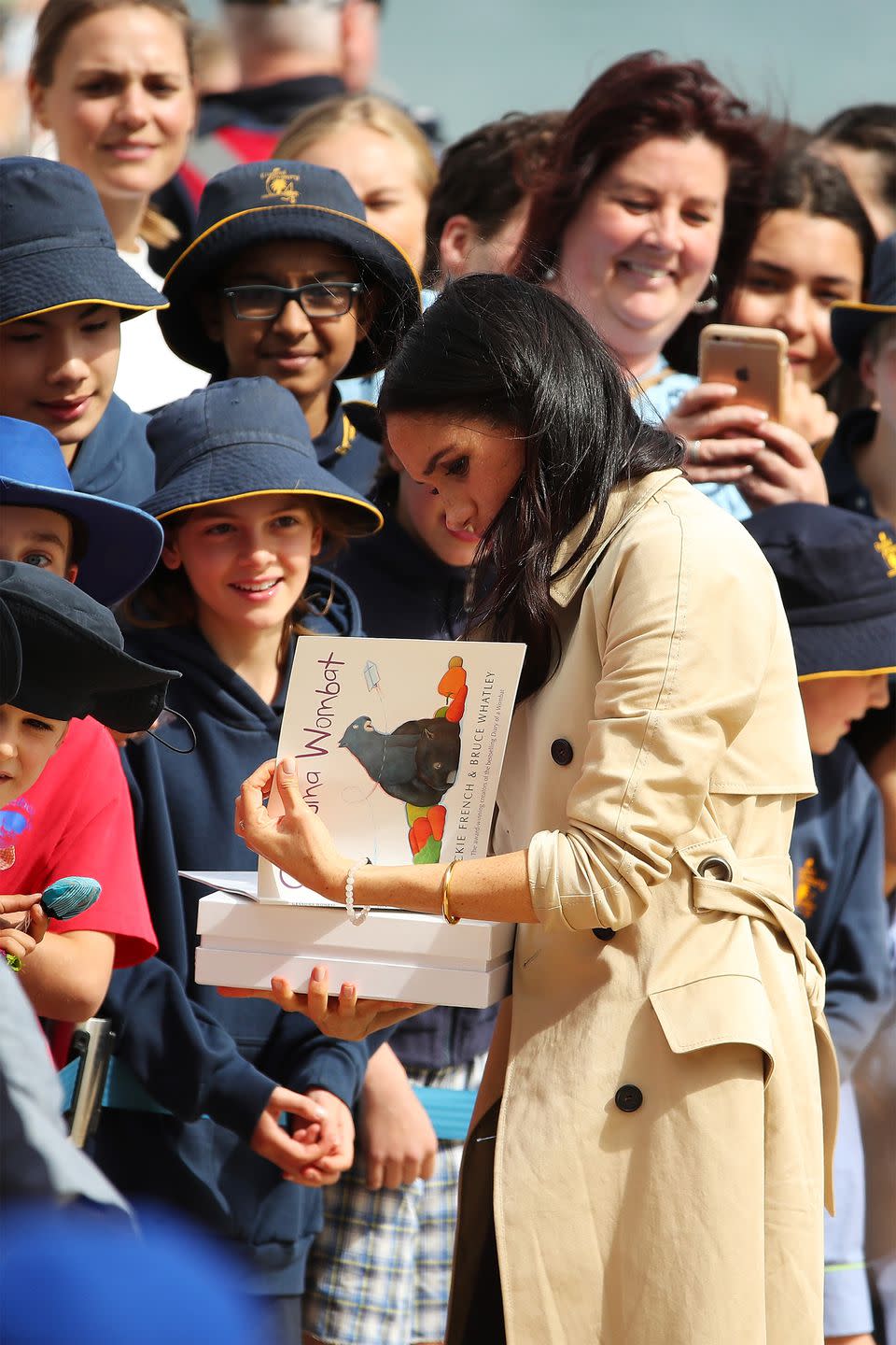 <p>Meghan accepts a gift from the crowd. </p>