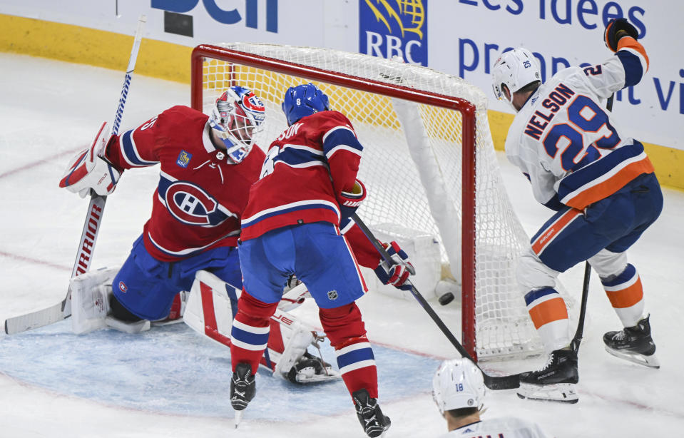 New York Islanders' Brock Nelson (29) scores against Montreal Canadiens goaltender Sam Montembeault, left, as Canadiens' Mike Matheson (8) defends during the third period of an NHL hockey match in Montreal, Saturday, Dec. 16, 2023. (Graham Hughes/The Canadian Press via AP)