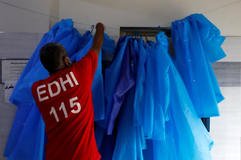 A volunteer of the Edhi Foundation, a non-profit social welfare programme, hangs up raincoats to be used to handle suspected carriers of the coronavirus disease (COVID-19), in Karachi, Pakistan