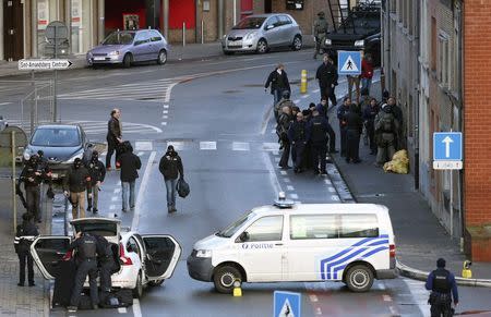 Belgian police officers and special forces stand at the entrance of a building, where four gunmen have taken a man hostage, in Ghent December 15, 2014.REUTERS/Francois Lenoir