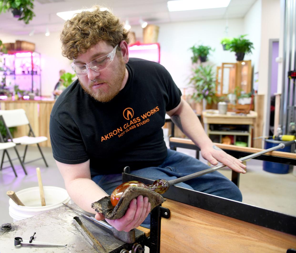 Artist Sebastian Shepherd of Norton works on a hand-blown glass piece at The Glass Garden of Canton.