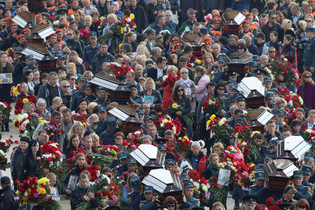 People attend a memorial ceremony before the funeral of victims of an attack on a local college in the city of Kerch, Crimea October 19, 2018. REUTERS/Pavel Rebrov