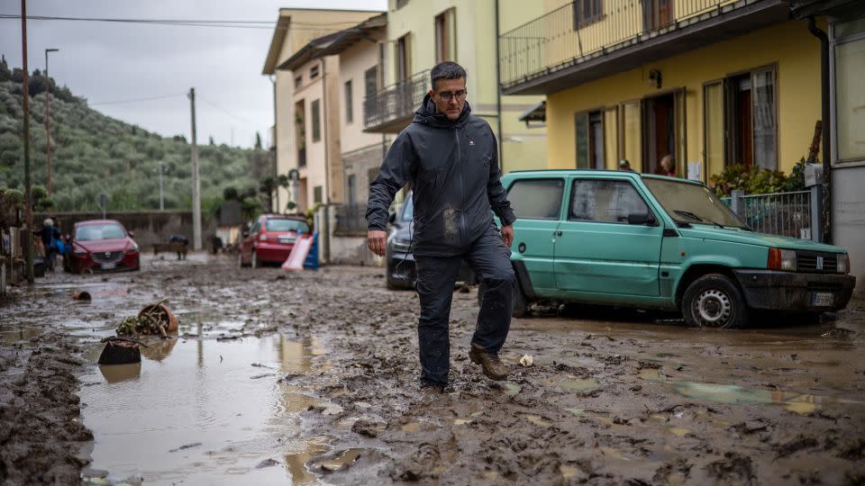 A man walks in the mud in Montemurlo, near Prato, after torrential rain hit the area, on November 3, 2023. - Federico Scoppa/AFP/Getty Images