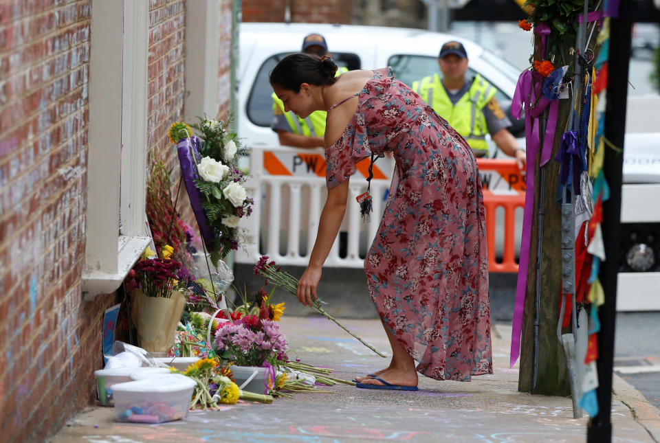 <p>A woman leaves flowers at a memorial to Heather Heyer ahead of the one-year anniversary of 2017 Charlottesville “Unite the Right” protests, in Charlottesville, Va., Aug. 11, 2018. (Photo: Jim Urquhart/Reuters) </p>