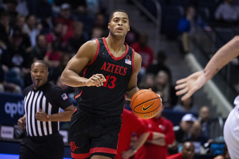 San Diego State forward Jaedon LeDee (13) brings the ball up against BYU during the first half of an NCAA college basketball game Friday, Nov. 10, 2023, in Provo, Utah. (AP Photo/Isaac Hale)