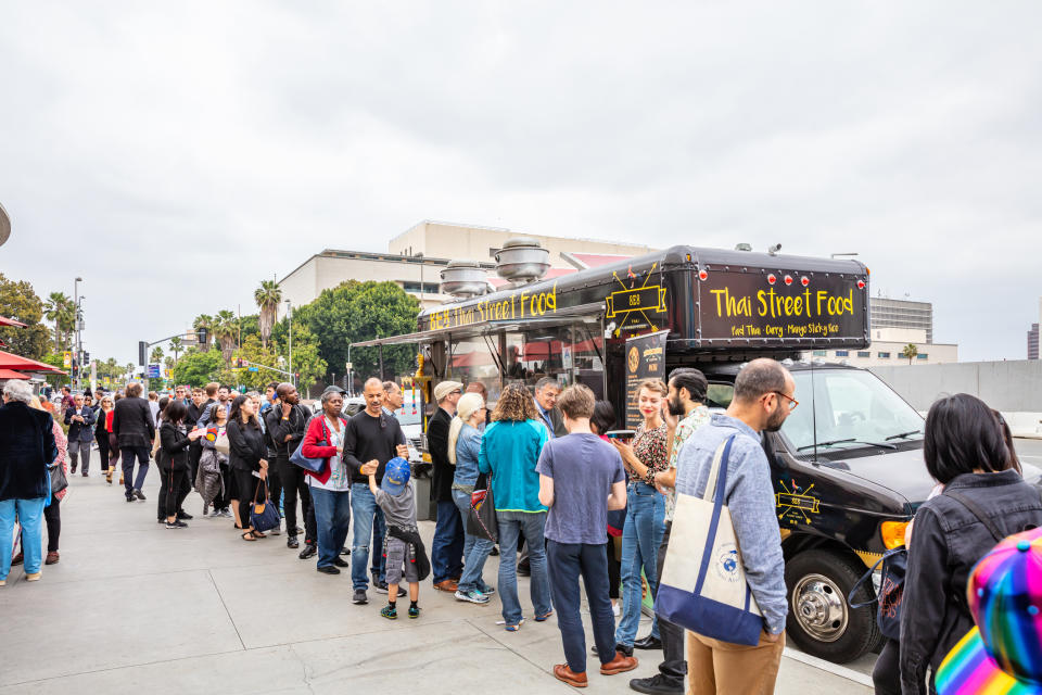 People waiting in line outside of a food truck