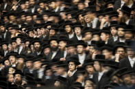 <p>Ultra-Orthodox Jews of the Wiznitz Hasidim celebrate the Jewish feast Tu Bishvat or Tree New Year as they sit with their rabbis at a long table filled with fruits in the ultra-Orthodox town of Bnei Brak near Tel Aviv, Israel, Feb. 8, 2012. (Photo: Oded Balilty/AP) </p>