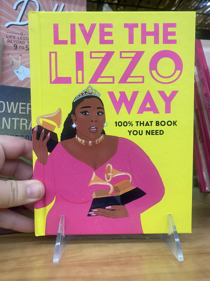 The cover of the book shows Lizzo holding multiple Grammy Awards and says "100% that book you need"