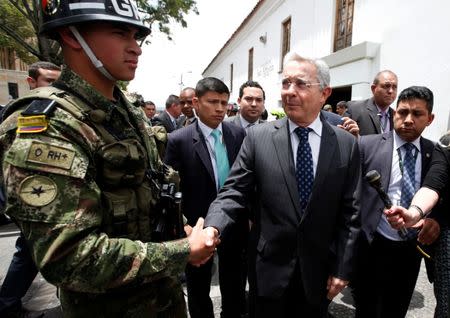 Colombian former President and Senator Alvaro Uribe (C) shakes hands with a soldier before a meeting with Colombia's President Juan Manuel Santos at Narino Palace in Bogota, Colombia, October 5, 2016. REUTERS/John Vizcaino