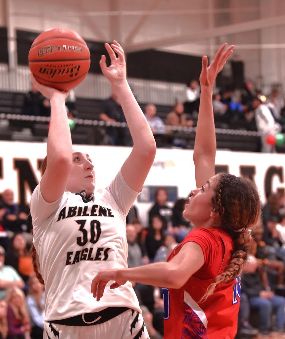 Abilene High's Grace Jordan, left, shoots over an Abilene Cooper defender in the first half. The Lady Eagles beat Cooper 43-34 in the District 4-5A girls basketball game Friday, Dec. 15, 2023, at Eagle Gym.