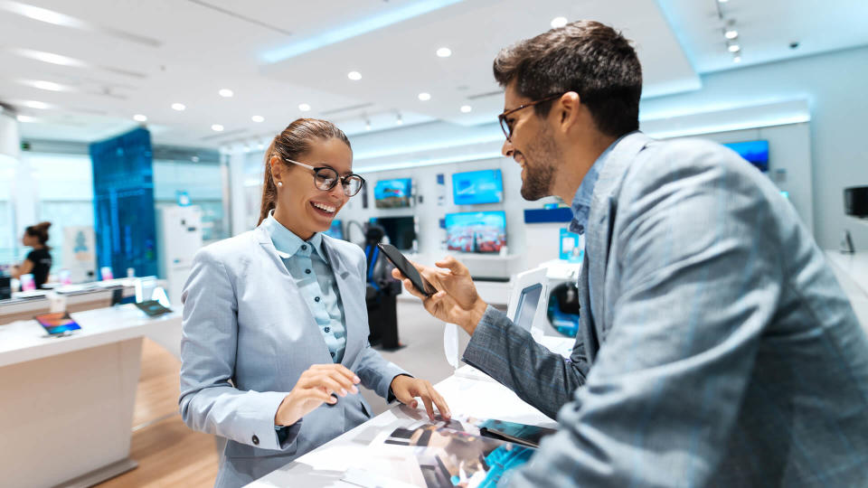 Young multicultural couple looking for new smart phone to buy.