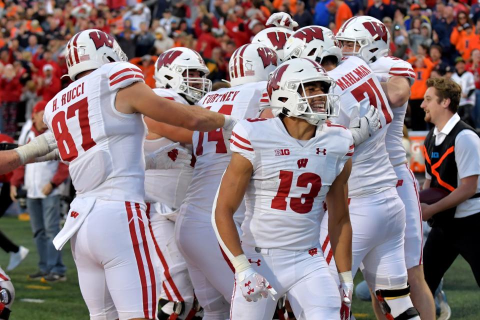 Oct 21, 2023; Champaign, Illinois, USA; Wisconsin Badgers players celebrate a touchdown during the second half against the Illinois Fighting Illini at Memorial Stadium. Mandatory Credit: Ron Johnson-USA TODAY Sports