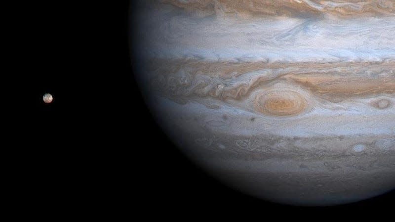 Jupiter and its moon Io as seen from the Cassini Spacecraft in 2000.